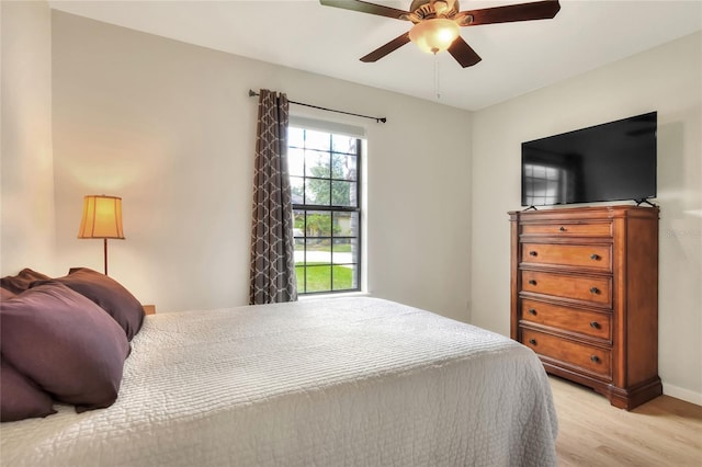 bedroom with light wood-style flooring, baseboards, and ceiling fan