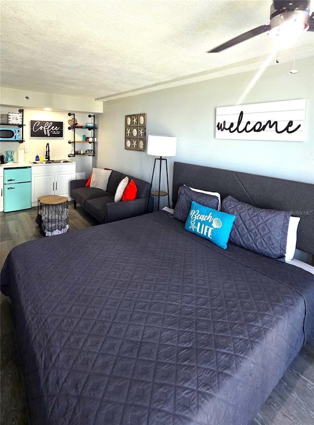 bedroom with a sink, a textured ceiling, dark wood finished floors, and ceiling fan