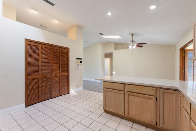 kitchen with visible vents, ceiling fan, light countertops, lofted ceiling, and light tile patterned flooring