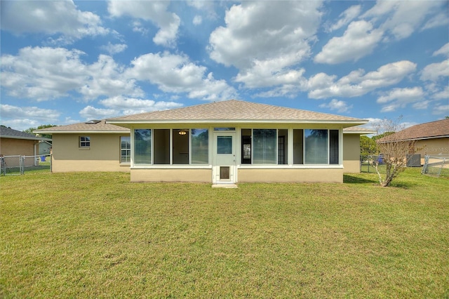 back of house featuring a gate, stucco siding, a lawn, and fence