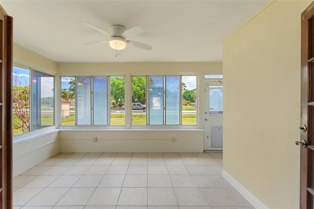 unfurnished sunroom featuring a ceiling fan