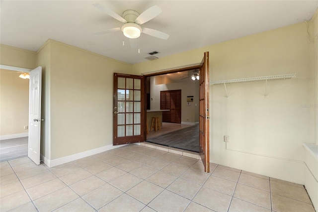 spare room with light tile patterned floors, baseboards, visible vents, and ceiling fan