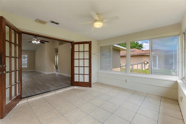 tiled empty room featuring visible vents, french doors, lofted ceiling, and ceiling fan