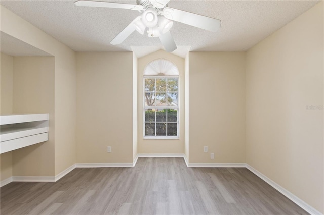 unfurnished room with ceiling fan, baseboards, a textured ceiling, and wood finished floors