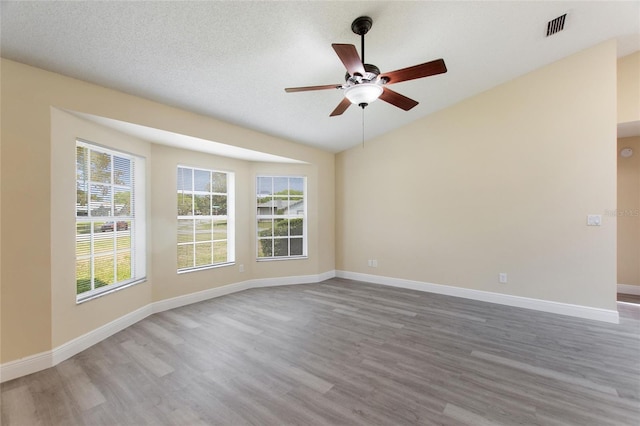 unfurnished room featuring baseboards, wood finished floors, and a ceiling fan