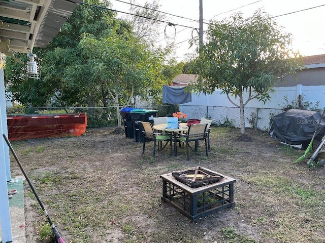 view of yard with outdoor dining space, an outdoor fire pit, and a fenced backyard