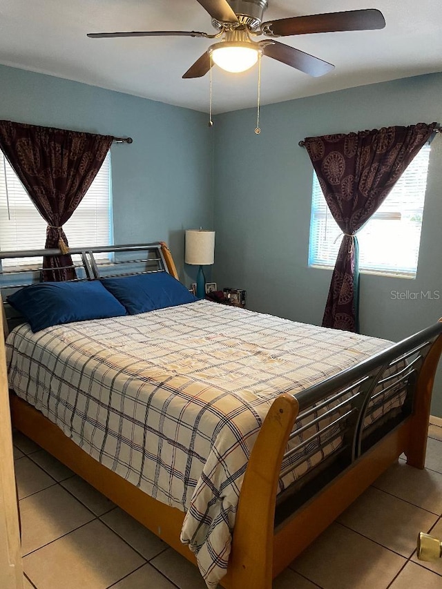 bedroom featuring tile patterned flooring, multiple windows, and ceiling fan