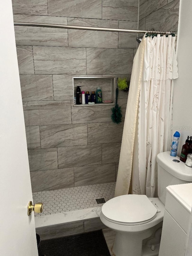 full bath with tiled shower and toilet