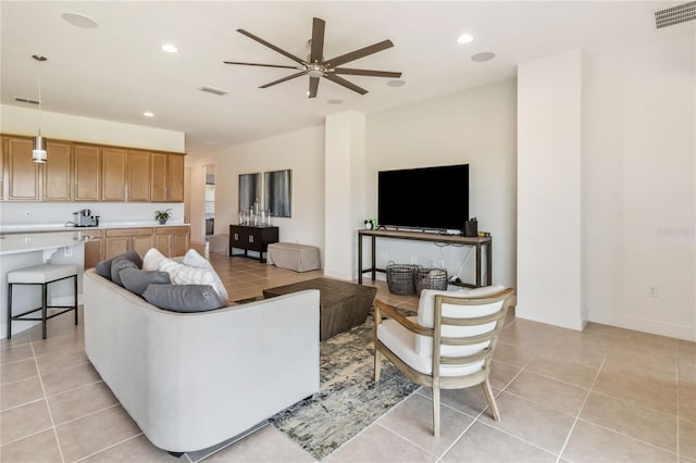 living room with light tile patterned floors, a ceiling fan, and visible vents