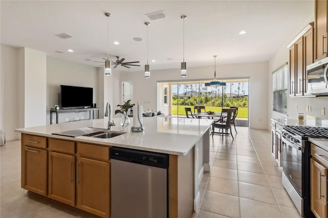 kitchen featuring visible vents, open floor plan, light countertops, stainless steel appliances, and a sink