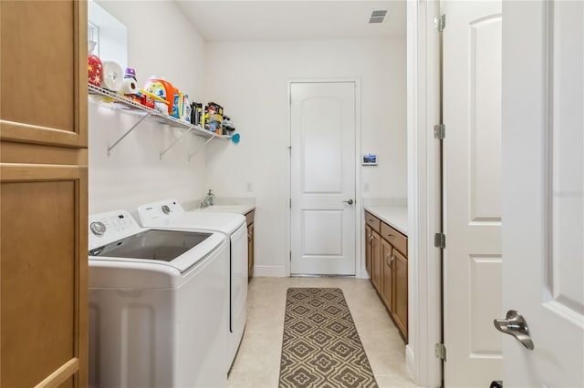 laundry room featuring cabinet space, washing machine and dryer, visible vents, and a sink