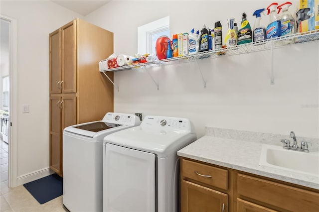 washroom with a sink, cabinet space, independent washer and dryer, and light tile patterned floors