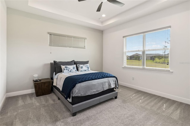 carpeted bedroom with recessed lighting, a tray ceiling, baseboards, and a ceiling fan