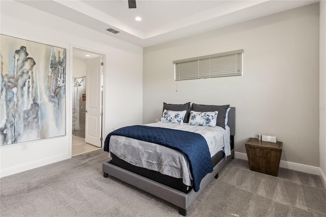 carpeted bedroom featuring visible vents, baseboards, recessed lighting, ensuite bathroom, and a raised ceiling