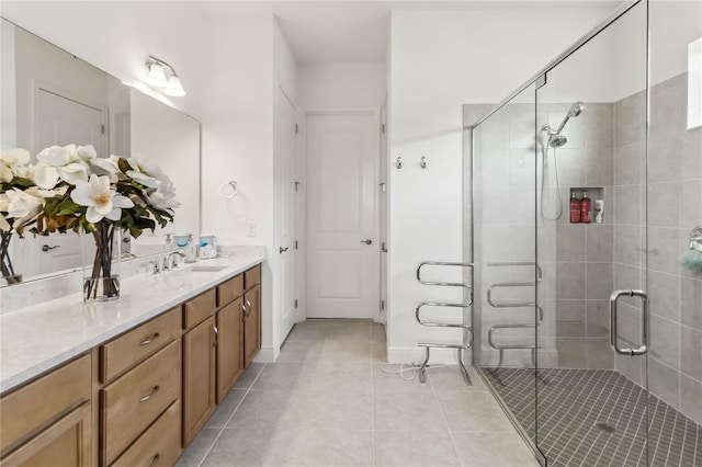 full bathroom featuring tile patterned floors, a stall shower, vanity, and baseboards