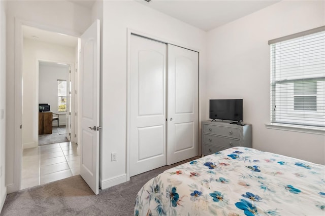 carpeted bedroom with a closet and tile patterned flooring