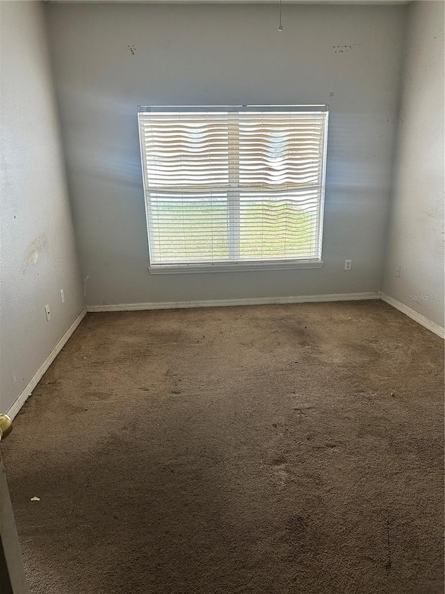 empty room with carpet and baseboards