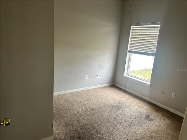 carpeted spare room with baseboards