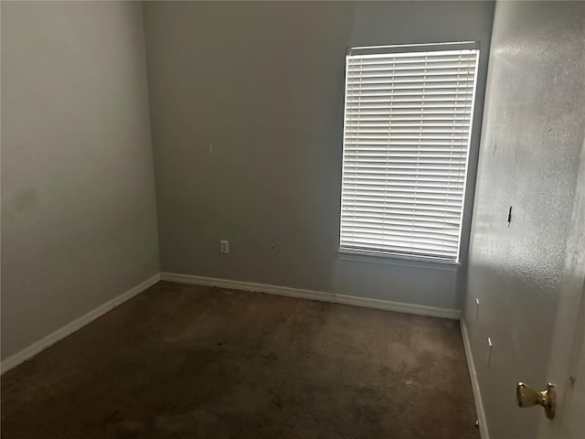 spare room featuring baseboards and carpet