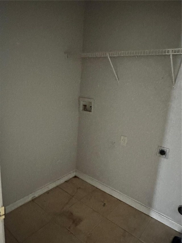 clothes washing area featuring tile patterned flooring, baseboards, hookup for an electric dryer, hookup for a washing machine, and laundry area