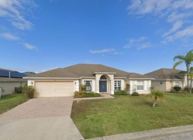 ranch-style house with a front yard, a garage, and driveway