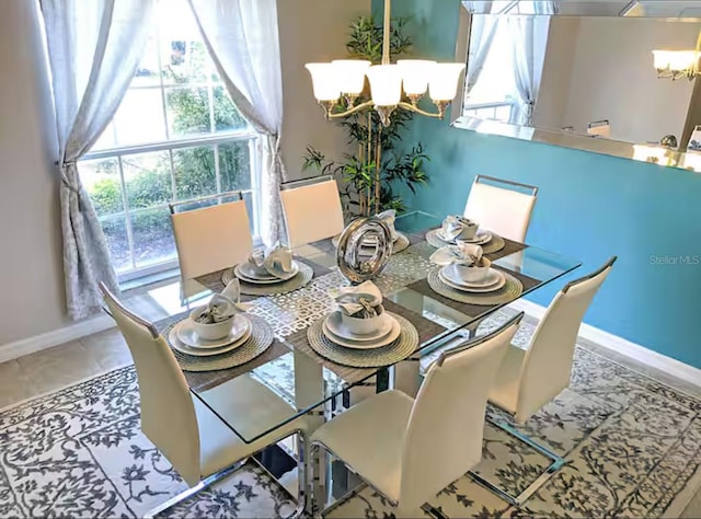 dining area featuring tile patterned flooring, a notable chandelier, and baseboards