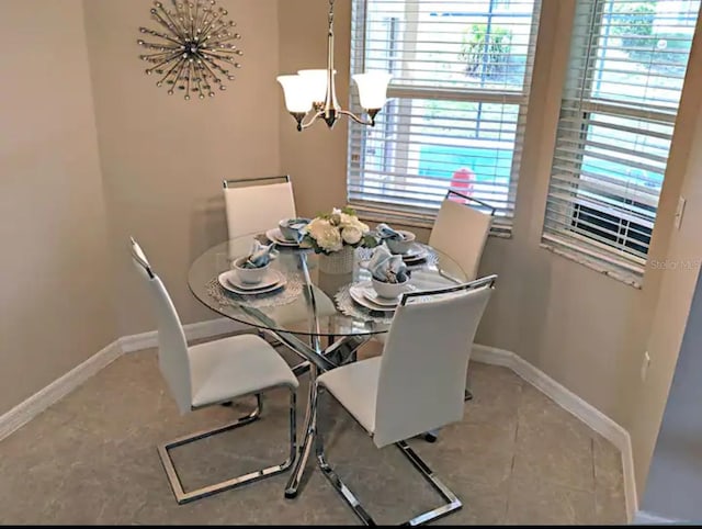 dining area featuring baseboards and a chandelier