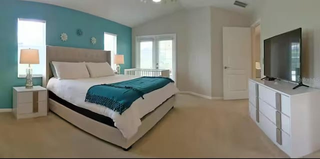 bedroom featuring light colored carpet, lofted ceiling, baseboards, and visible vents