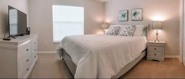 bedroom featuring light colored carpet and baseboards