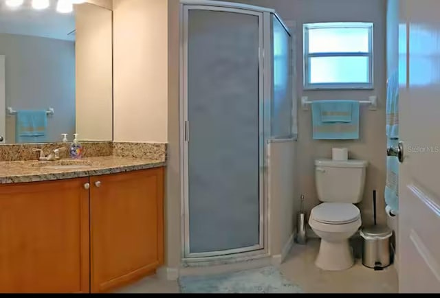 full bathroom with a shower stall, vanity, and toilet