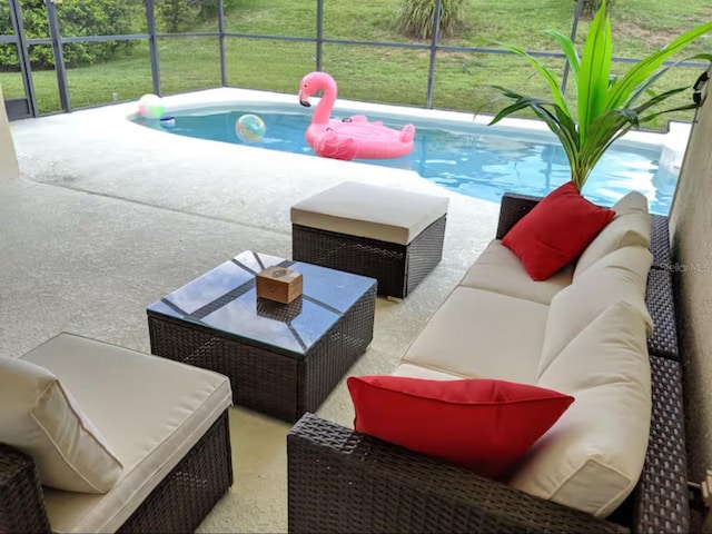 view of pool featuring glass enclosure, an outdoor hangout area, and a patio