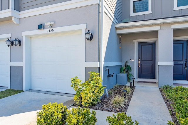 view of exterior entry featuring board and batten siding and stucco siding