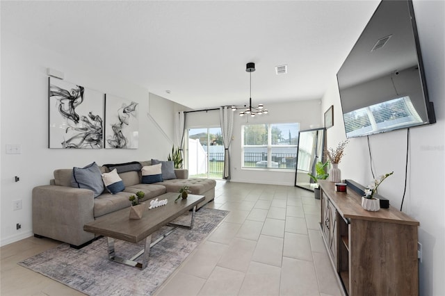 living room with light tile patterned floors, visible vents, and baseboards