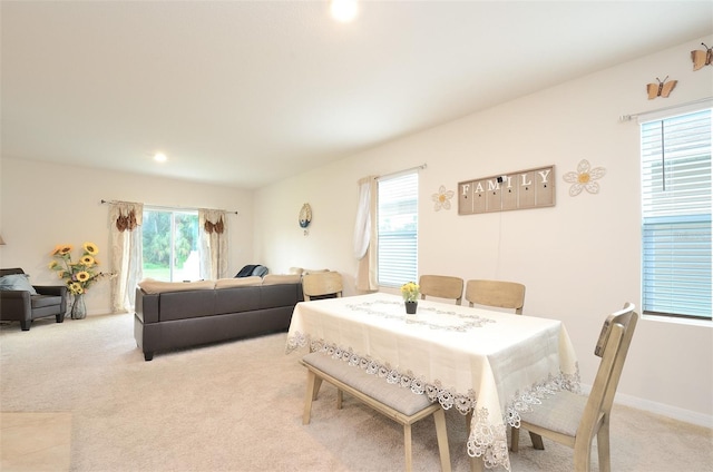 dining room with baseboards and light colored carpet