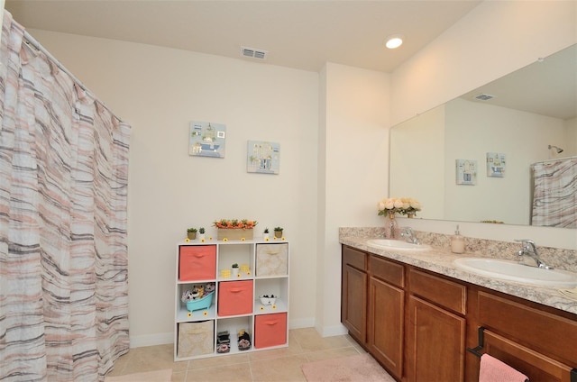 full bath with tile patterned flooring, double vanity, visible vents, and a sink