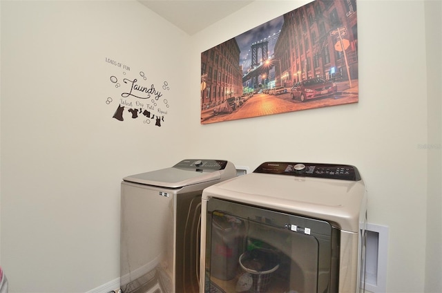 washroom with washer and clothes dryer, laundry area, and baseboards