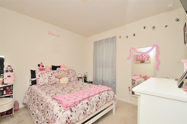 bedroom with baseboards and light colored carpet