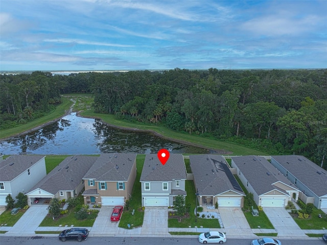 aerial view with a residential view, a view of trees, and a water view