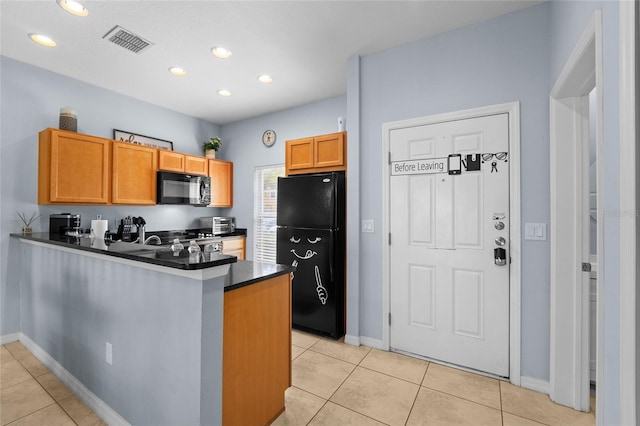 kitchen with visible vents, black appliances, dark countertops, a peninsula, and light tile patterned floors