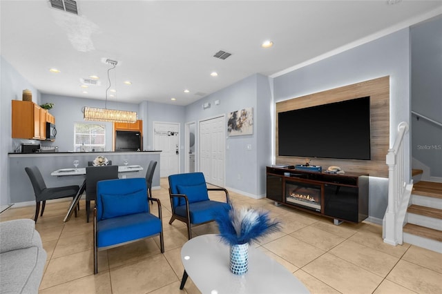 living area with light tile patterned floors, visible vents, and stairs