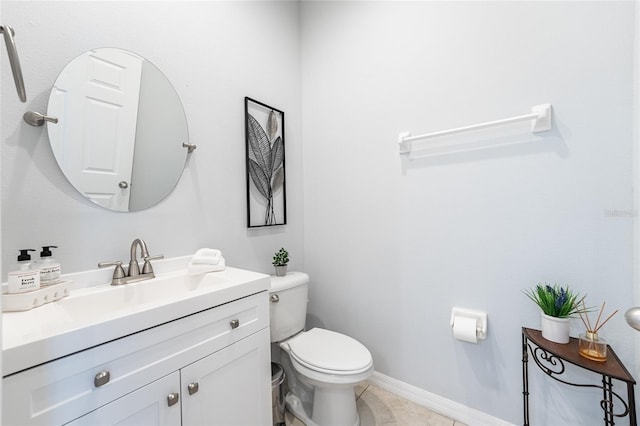 half bathroom featuring tile patterned flooring, toilet, vanity, and baseboards