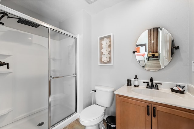 bathroom with vanity, toilet, and a shower stall