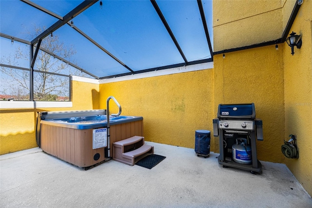 view of patio / terrace with glass enclosure and a hot tub