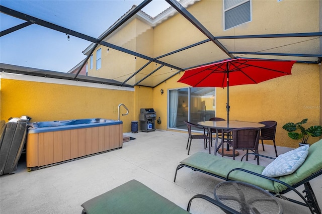 view of patio featuring glass enclosure, a hot tub, and outdoor dining area