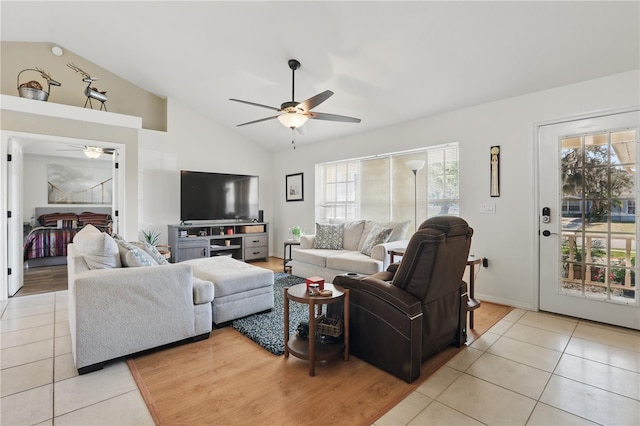 living area with lofted ceiling, light tile patterned flooring, and a ceiling fan