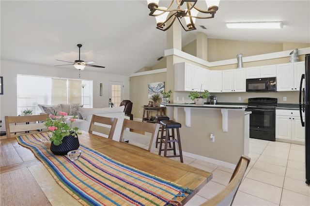 dining area with light tile patterned floors, ceiling fan with notable chandelier, and high vaulted ceiling