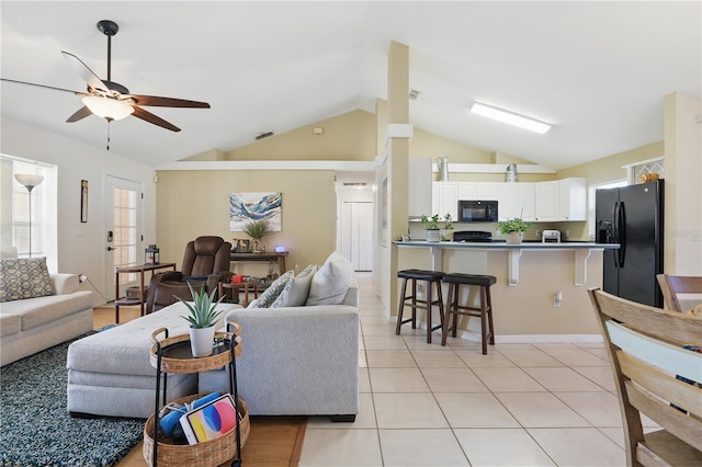 living area with light tile patterned floors, lofted ceiling, and ceiling fan