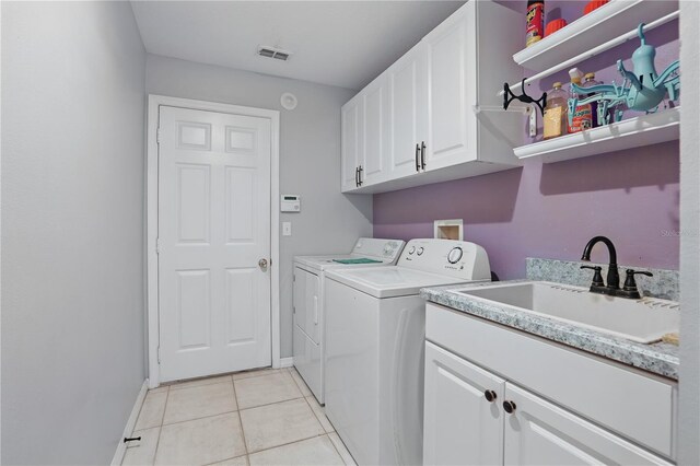 laundry room with visible vents, a sink, light tile patterned floors, cabinet space, and separate washer and dryer