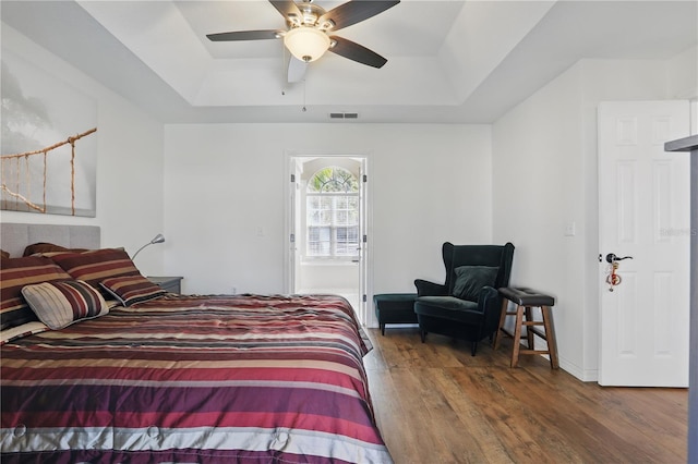 bedroom with visible vents, a raised ceiling, a ceiling fan, and wood finished floors