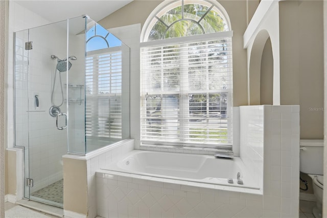 full bathroom with toilet, a bath, and a stall shower